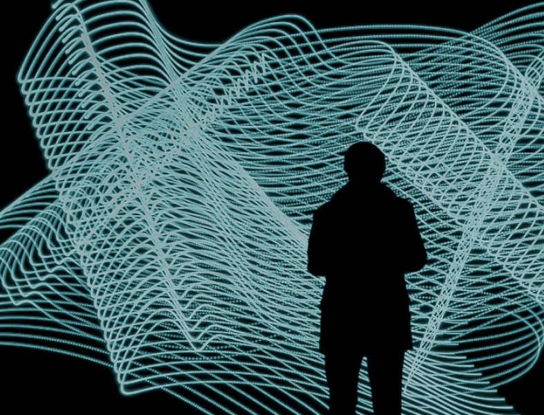 A dark silhouette of a person from the back against a light blue linear graphic